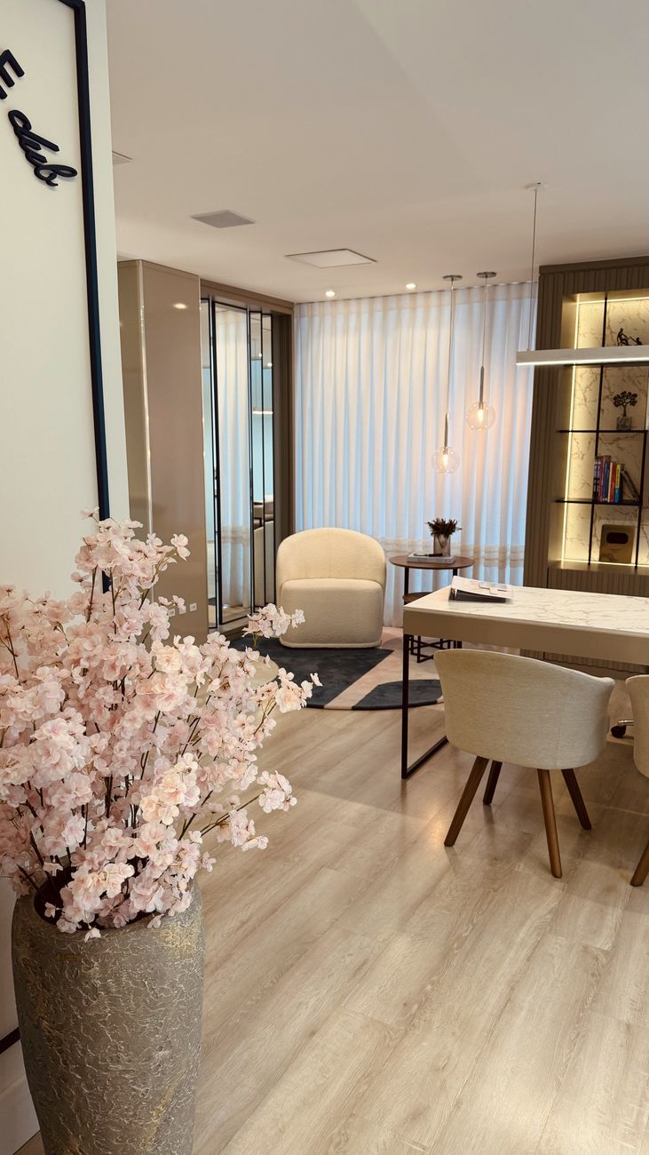 Sala de atendimento com poltronas claras e flores