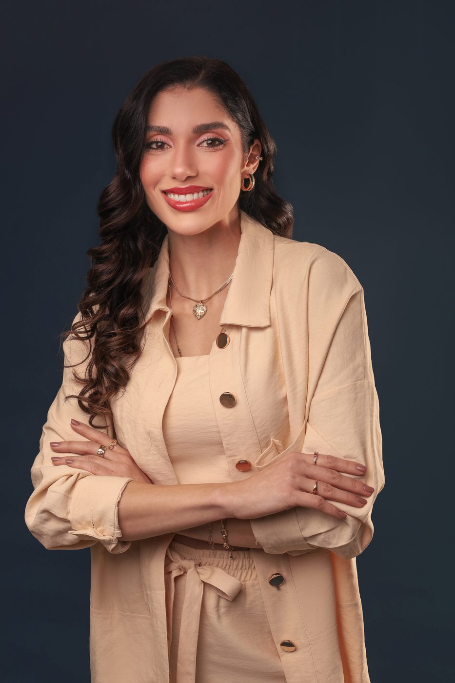 Dra. Beatriz Uthman sorrindo, de braços cruzados, em retrato de estúdio